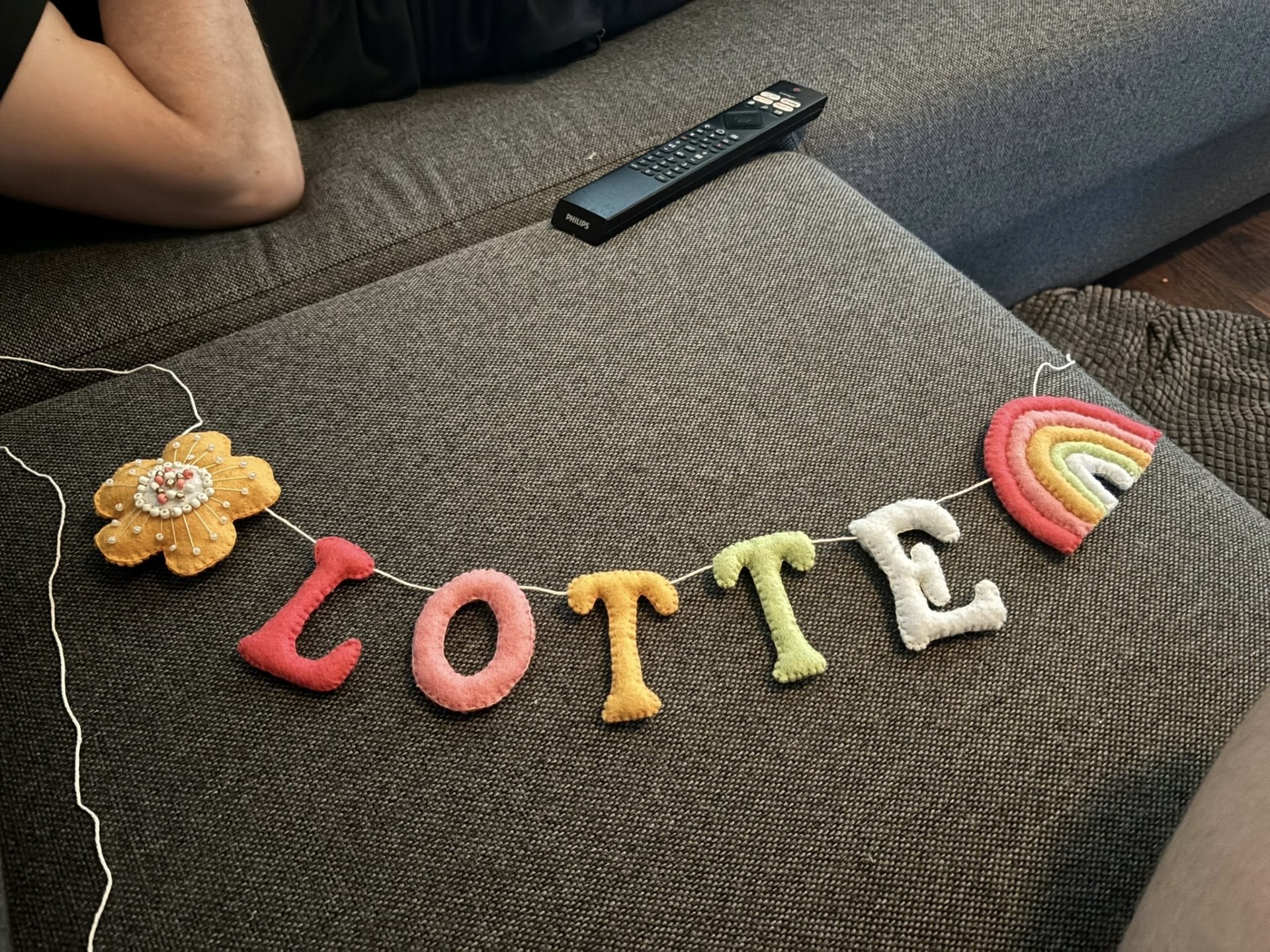 Slinger Lotte met regenboog en handgestikte bloem